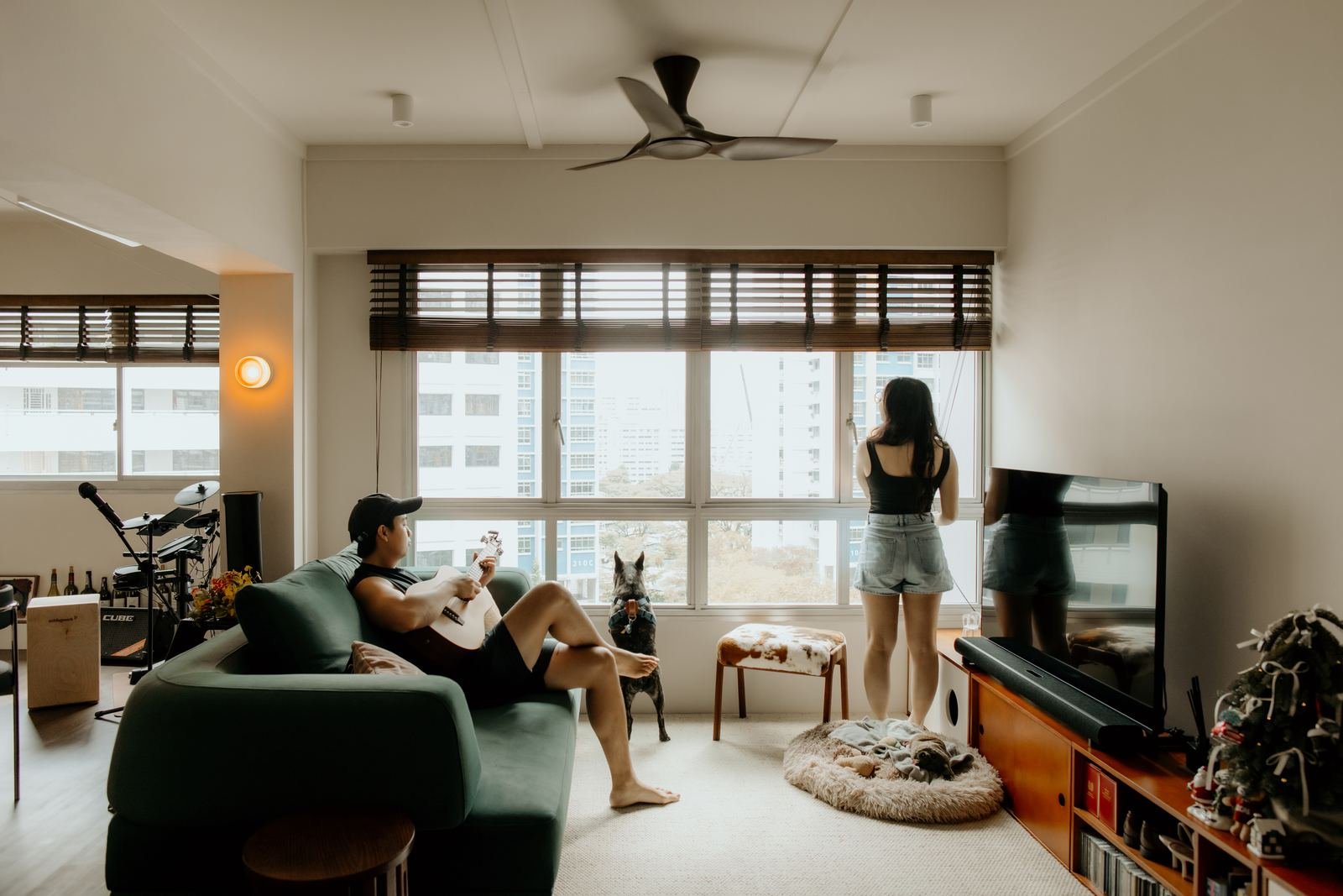 Couple relaxing at home with their dog by the window